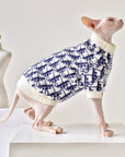 Devon Rex cat wearing mohair blend sweater, standing beside mannequin