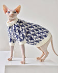 Hairless cat modeling mohair blend turtleneck sweater on display platform