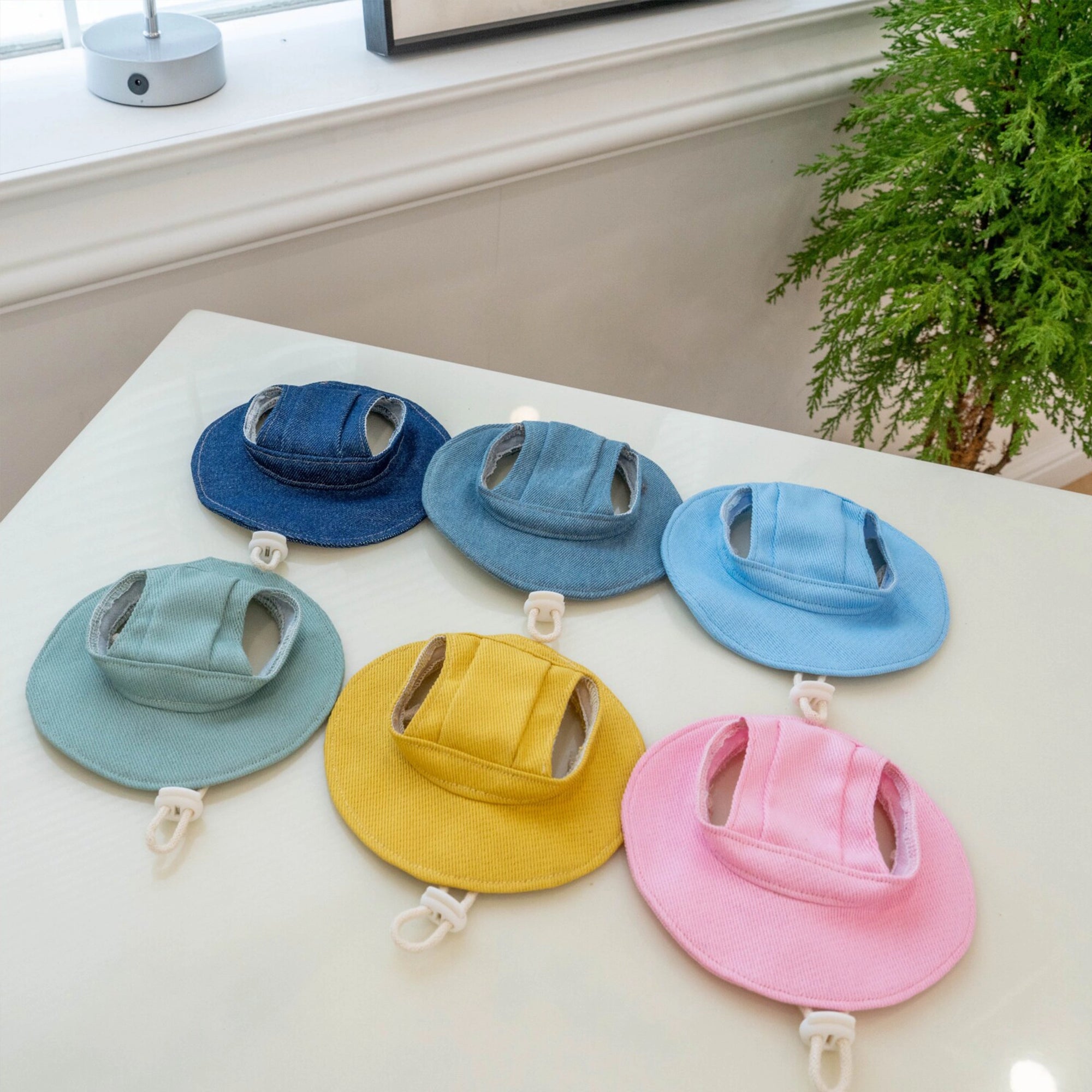 Cat sun hats with ear openings in six colors laid flat