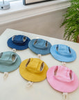 Cat sun hats with ear openings in six colors laid flat