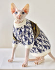 Sphynx cat wearing navy and white mohair blend sweater, full body front view