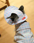 Close-up of ear-cutout design on pink plaid bucket hat, showing ear positioned through opening