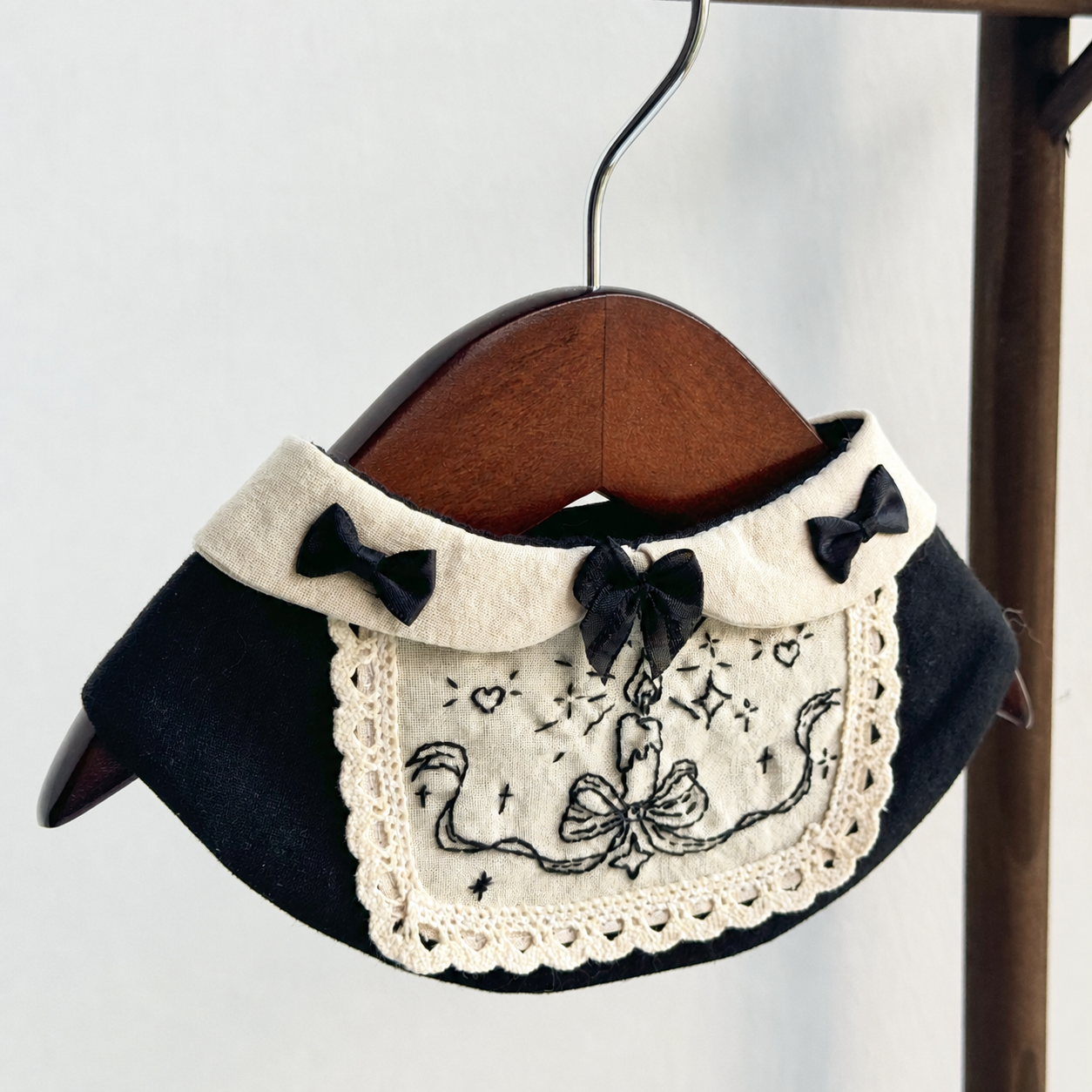 Halloween cosplay bib with embroidered candle motif and fabric bow details